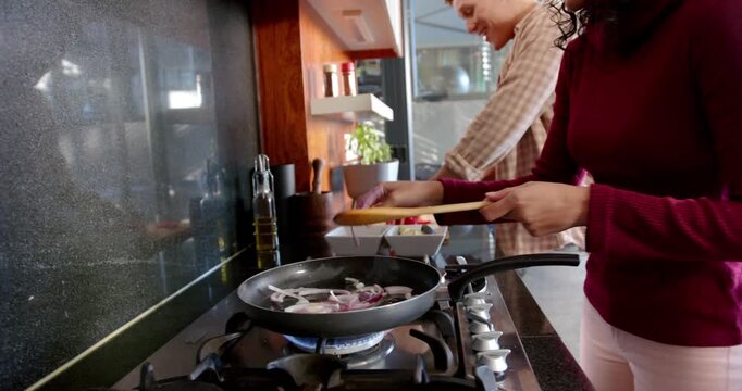 Lifestyle videos indoor of people doing activities at home, cooking onions in pan on stove, people p