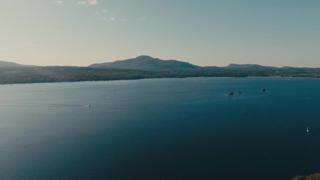 Calm Blue Waters Of Lake Memphremagog Toward Distant Mountain Peaks And Mount Orford In Quebec, Canada. - aerial shot