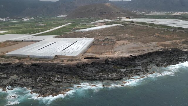 Aerial view approaching El Rayo sinkhole by coastal plantations and rugged shore