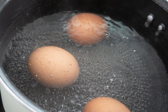 Cooking boiled eggs in hot water inside a cooking pot