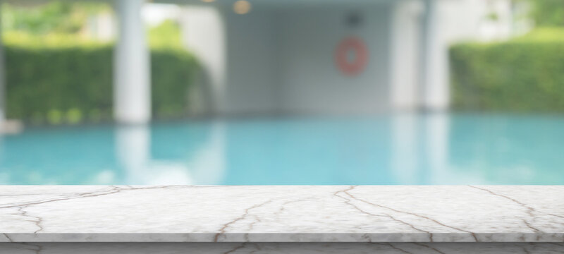 Empty marble table top with blur outdoor swimming pool in tropical resort hotel summer background
