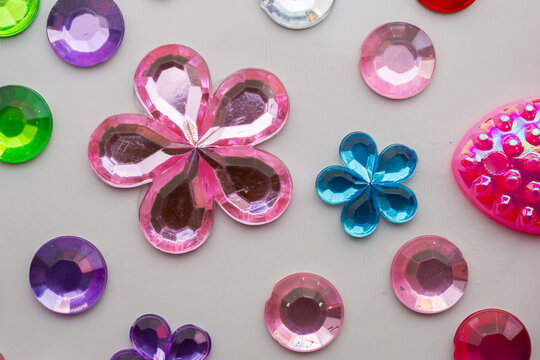 Colorful Flower Shaped Rhinestones and Plastic Gems Craft Accessories on White Background
