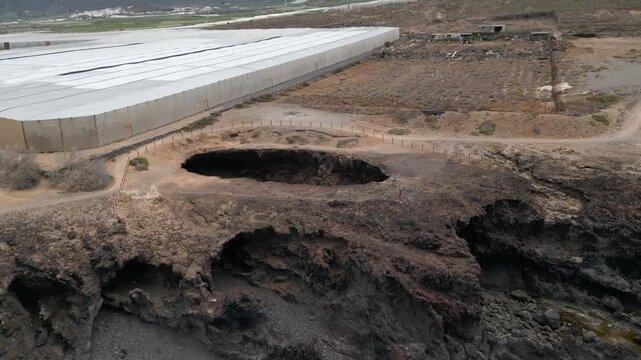 Aerial view of El Rayo sinkhole and natural arch near coastal footpaths and plantation