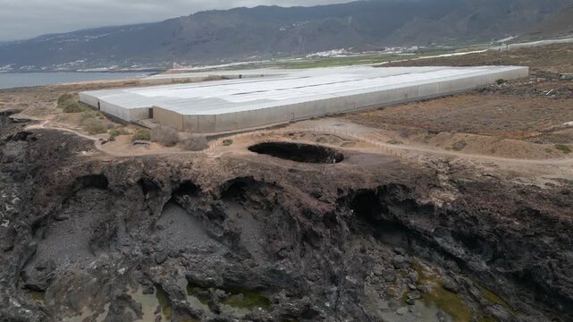 Aerial view of El Rayo sinkhole on rugged basalt cliffs near plantations and coast