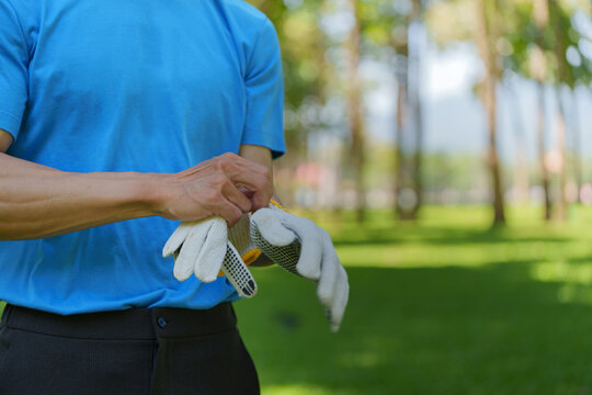 Volunteer putting on work gloves in park for community service