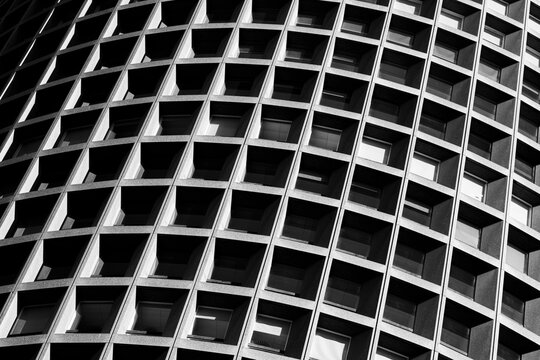 Curved grid facade in monochrome creates a striking abstract urban detail with repeating geometry depth and architectural rhythm and structure