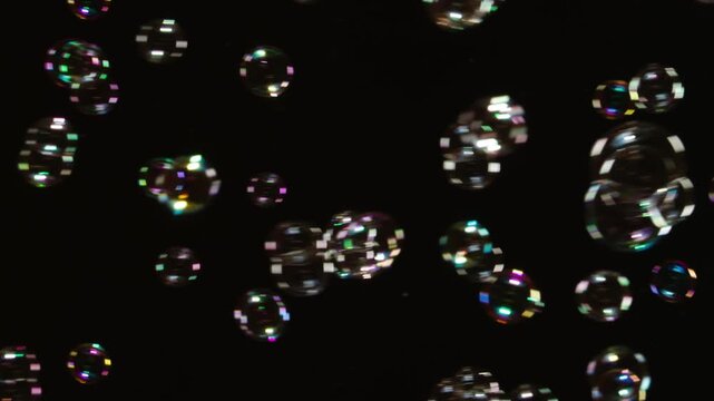 Soap Bubbles Floating on Black Background. A large number of soap bubbles moving in one direction against a black background. Great for use in blending