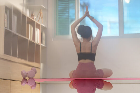 Woman practicing yoga in lotus pose at home for fitness lifestyle
