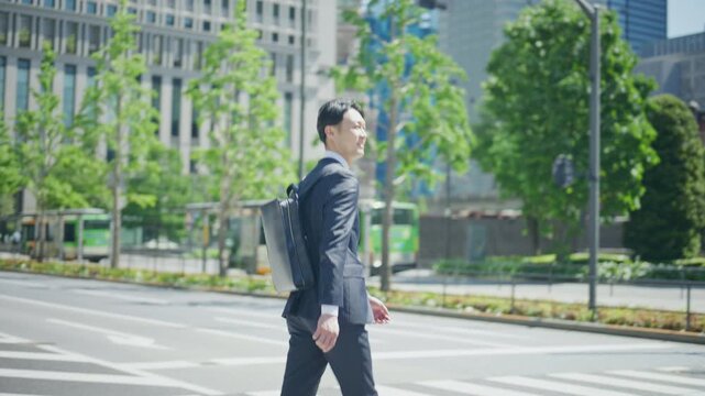 Businessman standing at a street corner near a bus stop in Tokyo