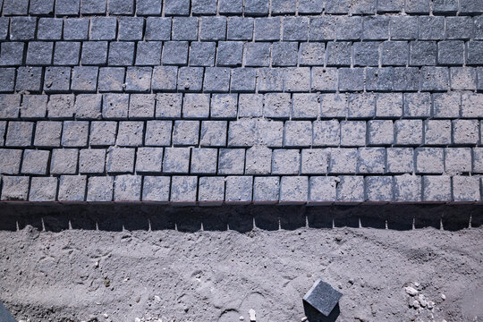 Granite cobblestone paving stones process on sand construction site
