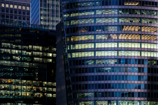 Illuminated office towers in La Defense Paris France form a dense evening cityscape with glowing windows and modern business architecture