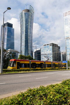 Modern tram passes office towers in Warsaw Poland showing urban mobility public transport and contemporary business district architecture in the city