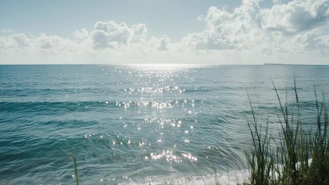 Sunlit ocean waves gently rolling onto a tranquil shore during a bright sunny day