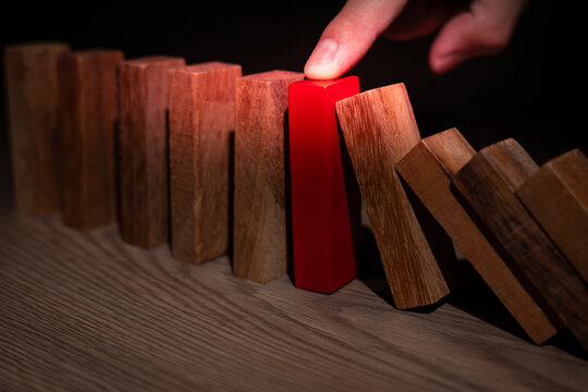 insurance with hands protect domino. Businessman hands stop dominoes falling in business crisis. business risk control and planning and strategies to run prevent insurance businesses.