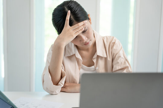 Headache, female having migraine pain, bad health, Asian woman feeling stress and headache, Office syndrome, sad tired touching forehead having migraine or depression, irritated girl, sadness grief