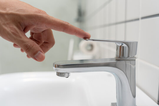Save water. Man keeps turning off the running water in the bathroom to protect environment. Greening planet, reduce global warming, Save world, life, future, risk energy, crisis , water day.