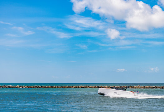 Luxury yacht heading out to sea from marina. Boating and yachting tourism. Luxurious lifestyle. Summertime vacation. Yacht at sea. Sea vacation on summer. Travel by sea. Luxury boat motor yacht