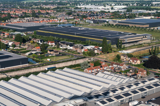 Commercial infrastructure building. Aerial warehouse distribution center with multiple loading docks. Parking infrastructure in industrial area. Logistic operation freight handling, storage