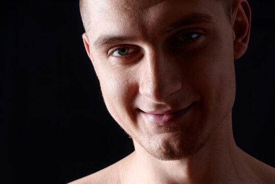Close-Up Portrait of Smiling Young Man with Black Background