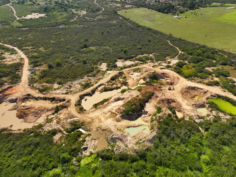 Aerial view of degraded soil by mineral extraction surrounded by plenty of nature