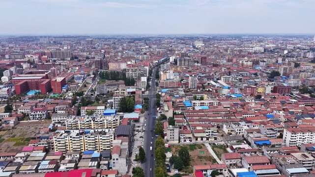 Aerial view of small Chinese city with dense residential buildings under blue sky