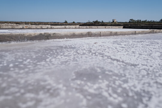  white sea salt crystals forming in evaporation pan at traditional salt marsh