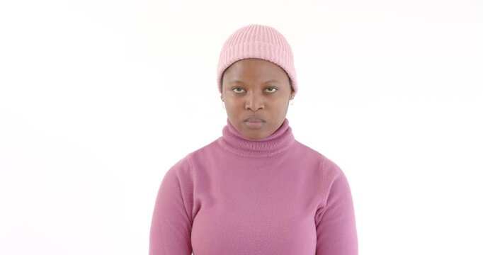 Person in pink sweater and beanie meditating with eyes closed, finding inner peace