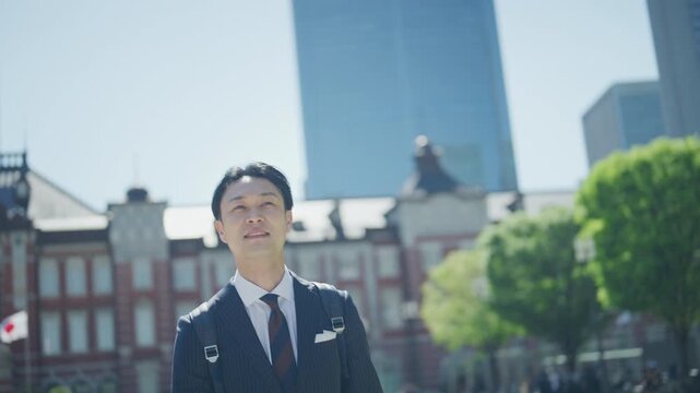 Smiling Japanese businessman in front of the red brick Tokyo Station building