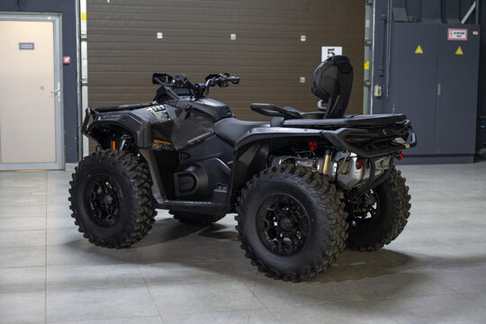 A rugged, aggressive black BRP Outlander ATV isolated on a solid black background. Powerful stance, mud-terrain tires, and detailed off-road design. Sharp studio lighting highlights the metallic frame