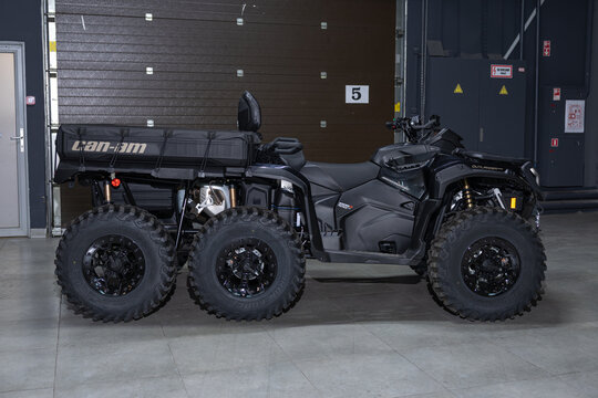 A massive black 6x6 BRP Outlander MAX ATV isolated on a solid black background. Rugged multi-axle design, aggressive stance, heavy-duty build, and sharp studio lighting emphasizing the powerful off-ro