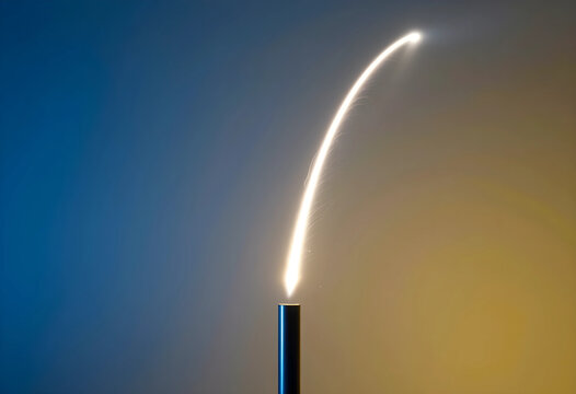 Innovation and growth concept, rocket launch trajectory with bright light trail rising from metal tube against blue and orange gradient background