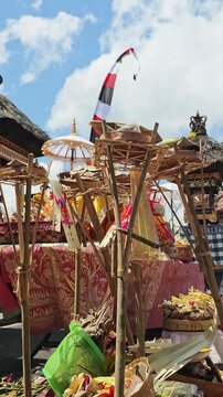 Traditional Balinese Hindu Offerings Set Up on Bamboo Stands During Temple Ceremony