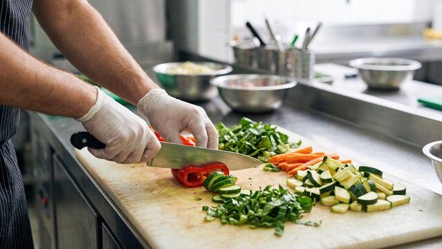 Food Worker Preparing Fresh Ingredients in Commercial Kitchen for Meal Service