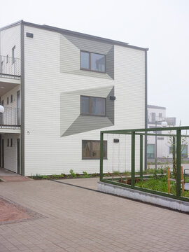 Apartment building next to sidewalk with fence