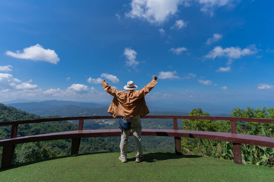 A tourist stands at a mountain viewpoint, gazing at the skyline scenery at Mon Jam, Chiang Mai, Thailand.