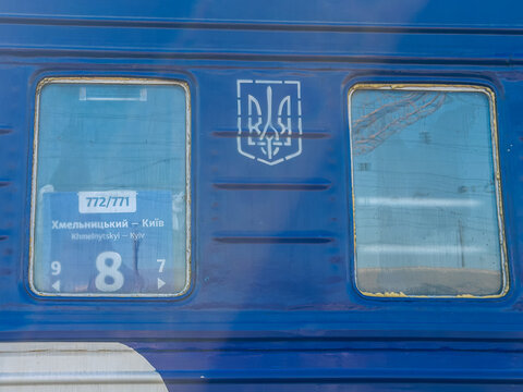 Khmelnytskyi, Ukraine - March 12, 2026: A blue passenger train carriage with the Ukrainian coat of arms, displaying route information for travel between Khmelnytskyi and Kyiv