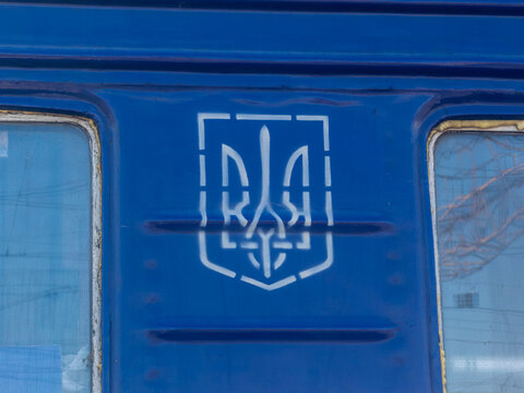 Khmelnytskyi, Ukraine - March 12, 2026: A white stencil of the Ukrainian Tryzub emblem painted on the blue metal side of a passenger train carriage, symbolizing national pride