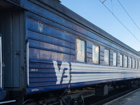 Khmelnytskyi, Ukraine - March 12, 2026: A blue Ukrainian Railways passenger carriage waits at a platform under a clear sky, highlighting modern public transportation infrastructure
