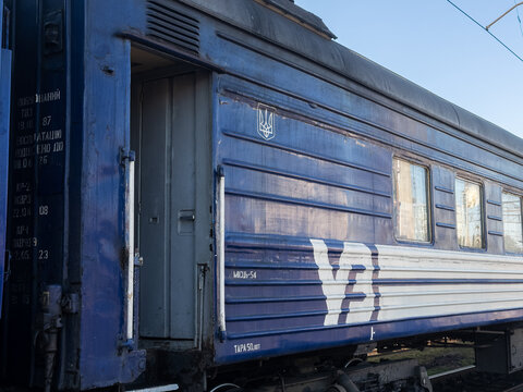 Khmelnytskyi, Ukraine - March 12, 2026: Ukrzaliznytsia passenger train carriage with an open door stands on railway tracks, highlighting public transport travel in sunshine