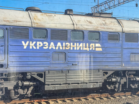 Khmelnytskyi, Ukraine - March 12, 2026: Ukrzaliznytsia electric locomotive travels on tracks, representing public national rail transport infrastructure in a clear daylight view