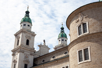 Fototapeta premium Green Copper Dome and Apse of Salzburg Cathedral against Blue Sky with Clouds in Salzburg, Austria.
