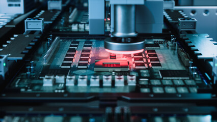 Plakat Pick and Place Head With Glowing Red Laser Ring Lowers Onto a Printed Circuit Board Lined With Microchips and Capacitors, Macro View of Automated Semiconductor Assembly in a Modern Plant