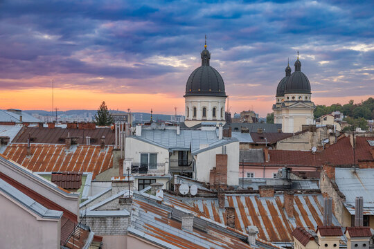 Domes of Transfiguration Church and old town city roofs against sunset sky