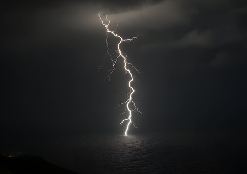Dramatic lightning bolt striking dark ocean water during heavy storm for powerful weather phenomena and nature energy photography