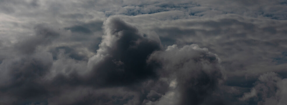 Dark thunderstorm clouds rainny season. Meteorology danger windstorm disasters climate. Banner Dramatic dark storm clouds black sky background. Dark thunderstorm clouds rainny atmosphere.