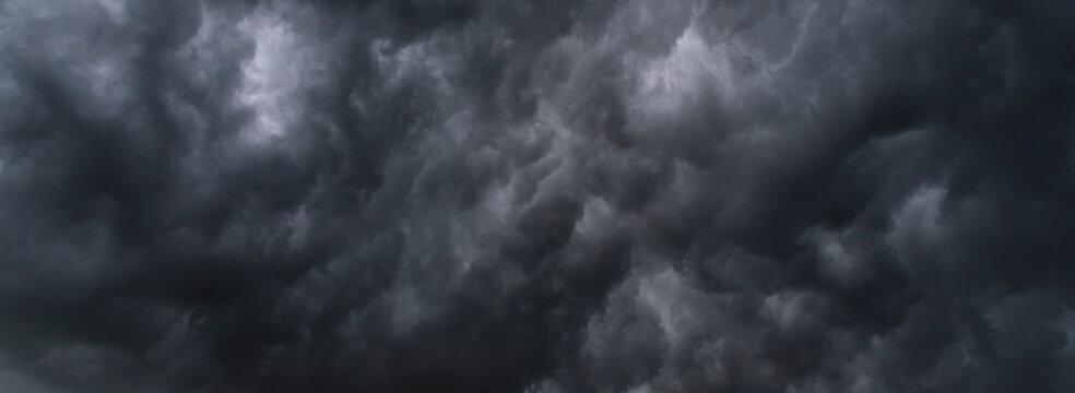 Dark thunderstorm clouds rainny season. Meteorology danger windstorm disasters climate. Banner Dramatic dark storm clouds black sky background. Dark thunderstorm clouds rainny atmosphere.