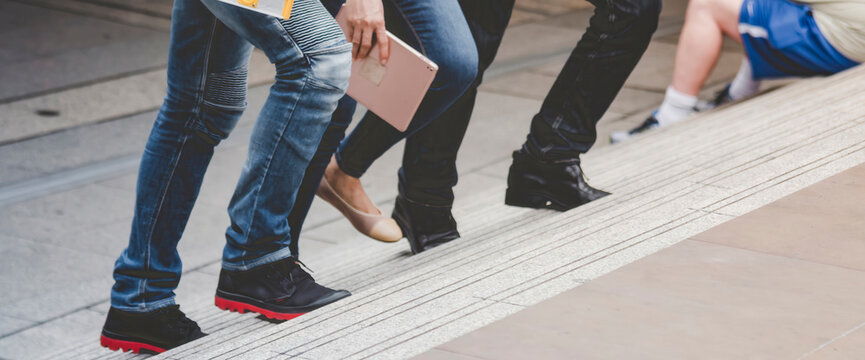 Banner Team engineer walking on stair in modern city together. Close up legs of team walk on street. Banner asian team step up, step down outside. Close up legs woman man walking city stair