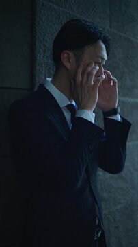 Japanese businessman standing with arms crossed in deep thought