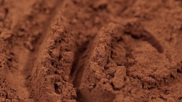 Cocoa powder pile close-up, rotation. Pastry chef. Brown cocoa powder texture circle rotation close-up. Chocolate	
