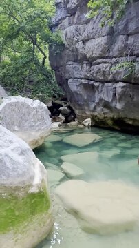 Stunning vertical video of a scenic turquoise river with ice-cold water flowing through a majestic and mystical canyon in Akseki, Turkey